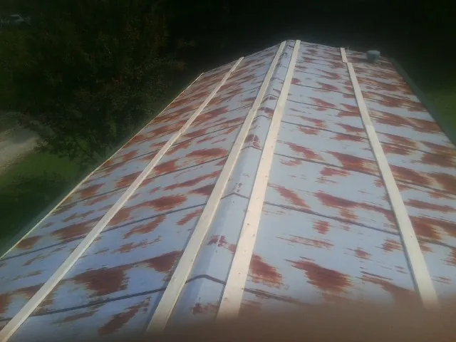Rusted metal roof panels with new wood purlins before replacement — Storm Damage Roof Repair in Cedar Mountain by Roofing Brothers