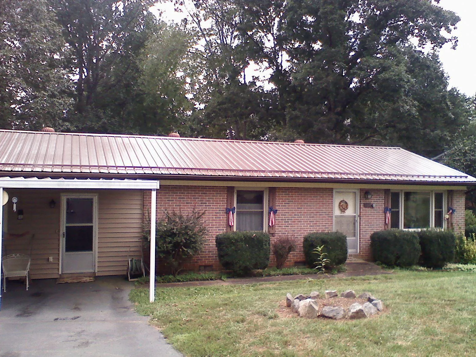 Bronze metal roof and carport on a brick ranch home — Roof Repair work by our crew in Cedar Mountain